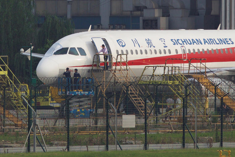 Trabajadores revisan el avión de Sichuan Airlines el lunes después del accidente. 