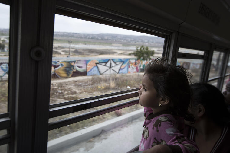 Una niña migrante centroamericana mira el muro fronterizo en Tijuana, México, el 29 de abril de 2018.