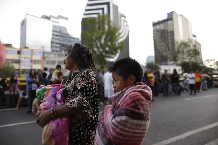 Personas esperan en la calle mientras escuchan la alarma sísmica en la Ciudad de México