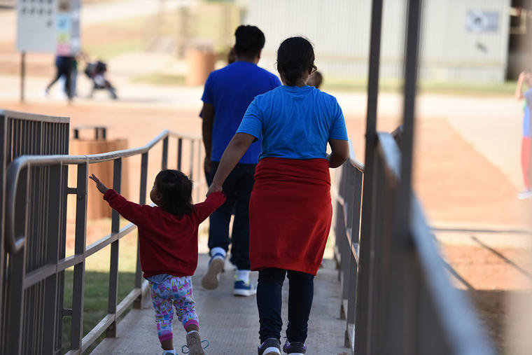 Una familia reunida camina en las afueras del South Texas Family Residential Center en Dilley, Texas. 