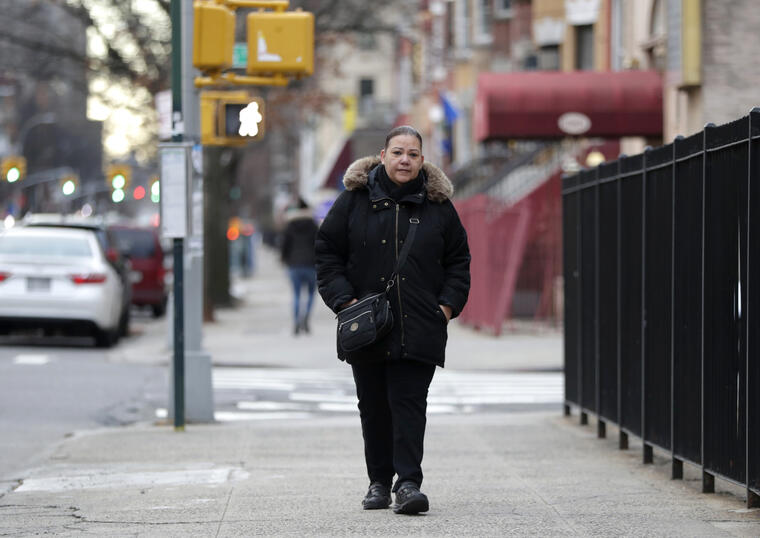 Flavia Cabral camina en el Bronx, en Nueva York. Cabral, quien tiene dos trabajos, será una de las beneficiarias del aumento del salario mínimo - a 15 dólares por hora - que entra en vigor el 31 de diciembre del 2018. 
