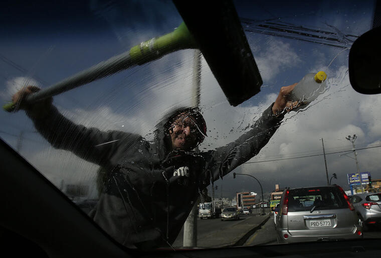 Un migrante venezolano limpia los cristales delnateros de un carro en Quito, la capital de Ecuador. 