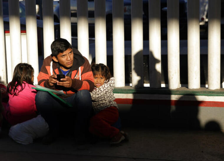 Un migrante y sus hijas esperan su turno en Tijuana, México, para presentar una solicitud de asilo en Estados Unidos. 