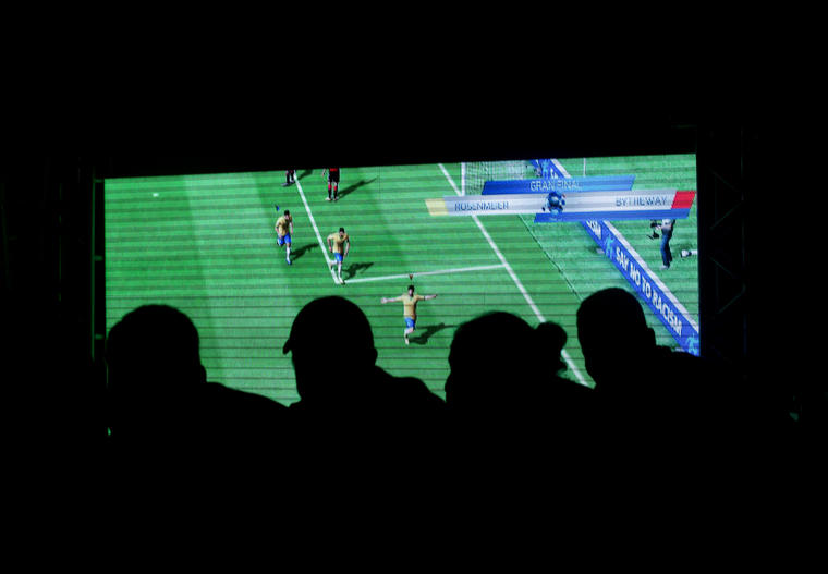 Fotografía de unas personas mirando un partido de fútbol en el Mundial de Brasil 2014.