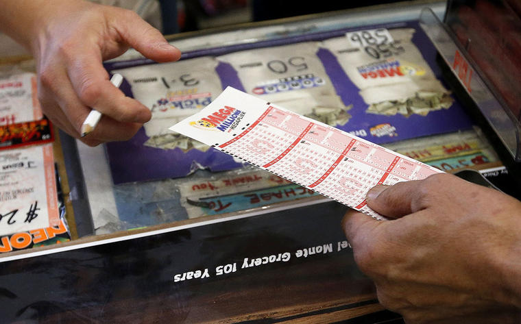 Una persona entrega en un supermercado los números que escogió para jugar en el Mega Millions de la lotería.