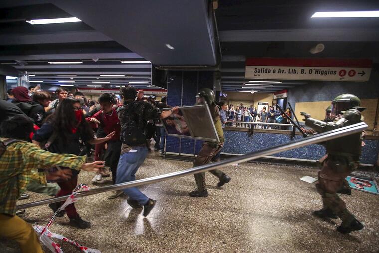 Manifestantes y fuerzas de seguridad se enfrentan este viernes en una de las estaciones del metro de Santiago de Chile. 