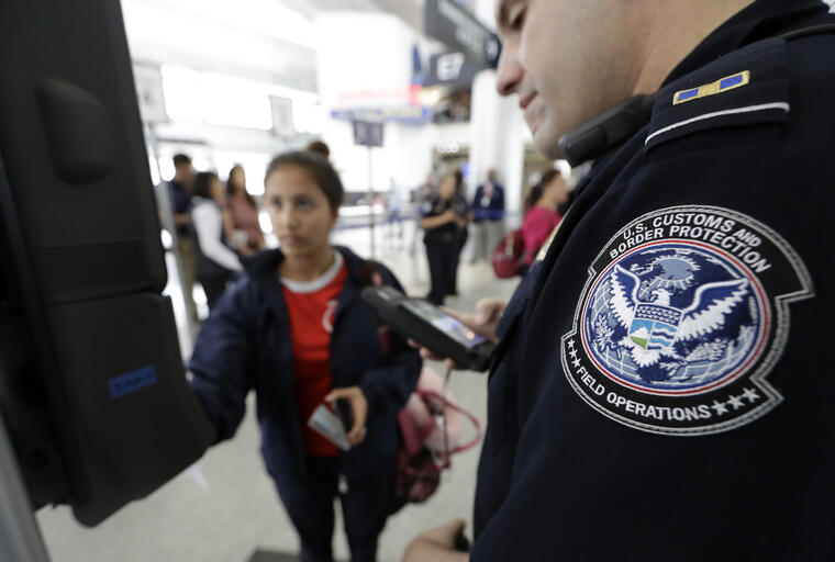 El oficial Julio Corro ayuda a una pasajera con el control de reconocimiento facial en el aeropuerto George Bush de Houston (Texas) el 12 de julio de 2017.  