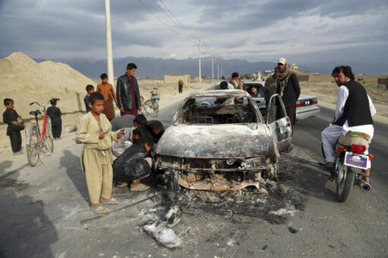 Afganos observan un vehículo civil quemado después de ser disparado por las fuerzas estadounidenses después de un ataque cerca de la base aérea de Bagram, al norte de Kabul, Afganistán, el martes 9 de abril de 2019. (AP/Rahmat Gul)