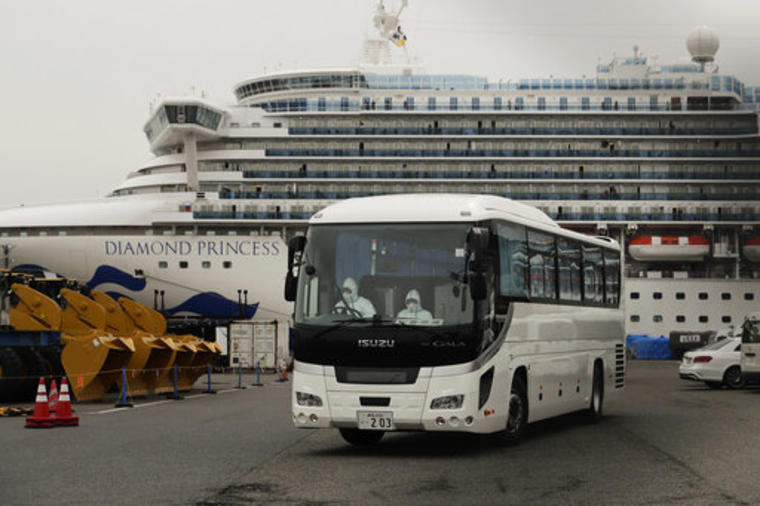 Un autobús abandona este sábado el puerto japonés de Yokohama, donde un crucero con miles de viajeros a bordo permanece en cuarentena por el coronavirus. 