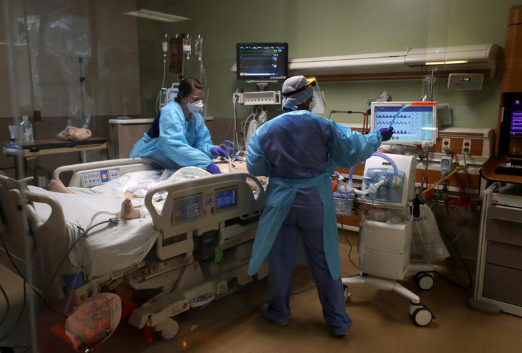 Dos enfermeras atienden a un paciente con coronavirus en la unidad de cuidados intensivos (UCI) en el Regional Medical Center de San José, California, el 21 de mayo de 2020. 