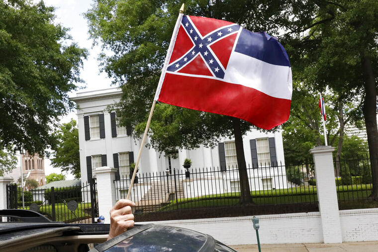 Un ciudadano sostiene una pequeña bandera del estado de Mississippi