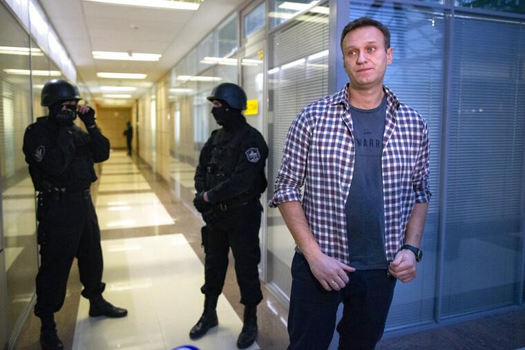 Aleksei Navalny habla a la prensa mientras dos agentes de seguridad lo vigilan, el pasado diciembre en Moscú. 