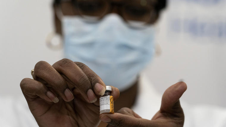La doctora Michelle Chester sostiene una dosis de Pfizer-BioNTech contra el COVID-19 antes de suministrar la vacuna a una enfermera en Queens, Nueva York. 