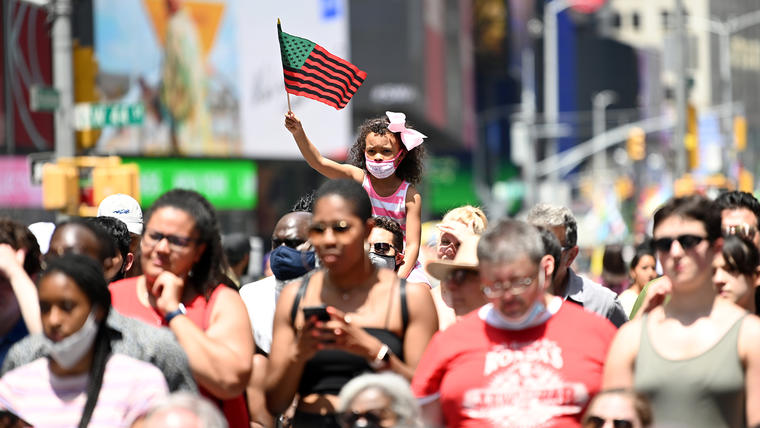 Una niña ondea una bandera afroamericana durante el Broadway Celebrates Juneteenth en Times Square el 19 de junio de 2021 en la ciudad de Nueva York.