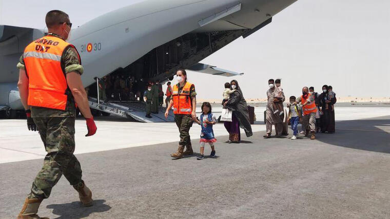 Afganos junto al avión español de las fuerzas armadas que ya se encuentra en el aeropuerto de Dubái, Emiratos Árabes Unidos, tras despegar desde el aeropuerto de Kabul con grupo de 110 personas evacuadas de Afganistán.