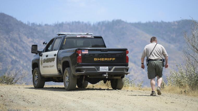 Un alguacil del condado de Mariposa vigila un área remota al noreste de la ciudad de Mariposa, California, el miércoles 18 de agosto de 2021, cerca del área donde una familia fue encontrada muerta.