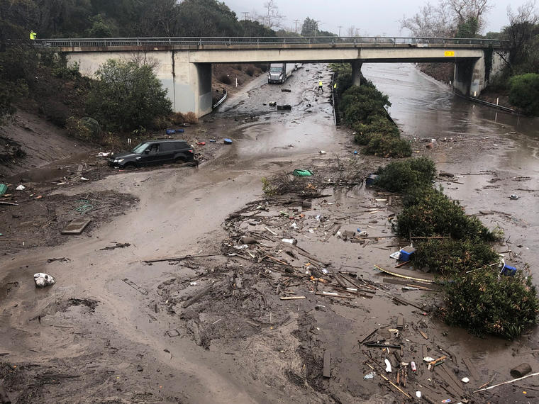 Carros varados y abandonados en una carretera inundada en Montecito, California