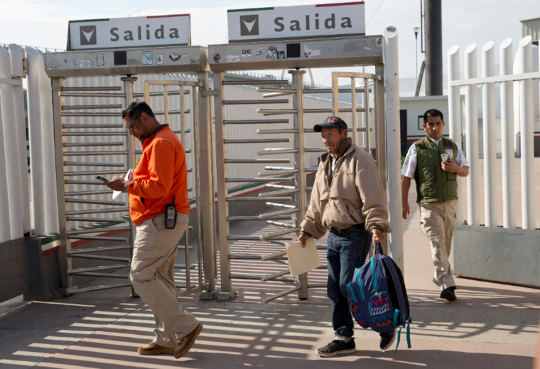 Carlos Catarldo Gómez (centro) este martes es escoltado por funcionarios mexicanos tras salir de Estados Unidos, la primera persona que regresó a México para esperar su fecha de juicio de asilo, en Tijuana.
