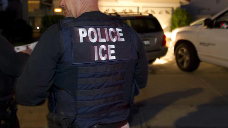 Foto de archivo de un agente de ICE frente a una casa