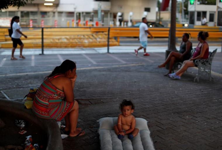 Una familia migrante espera este junio para solicitar asilo en EEUU en la entrada del puente internacional Puerta México en Matamoros, Tamaulipas, México.