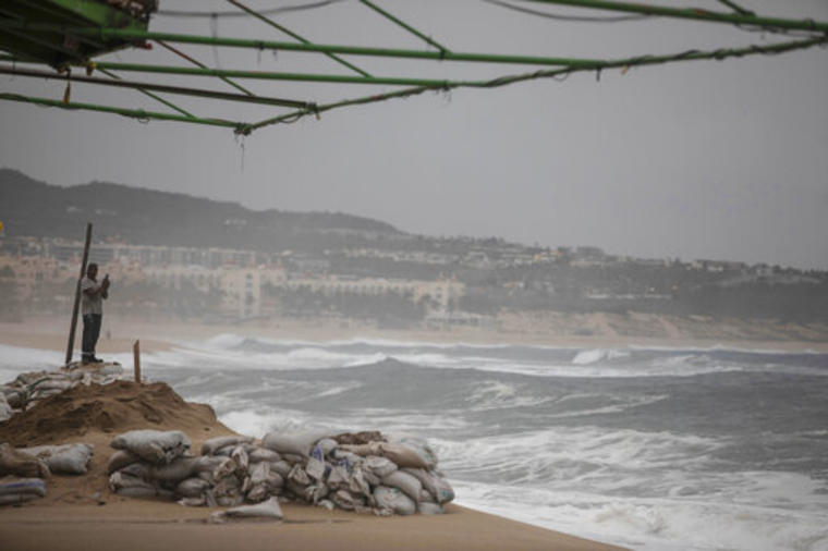 Un turista toma fotos del océano en la playa El Médano antes de la llegada esperada del huracán Lorena, en Los Cabos