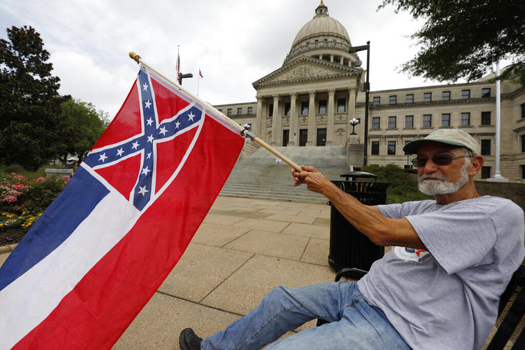 Un residente de Mississippi ondea la bandera estatal afuera del Capitolio