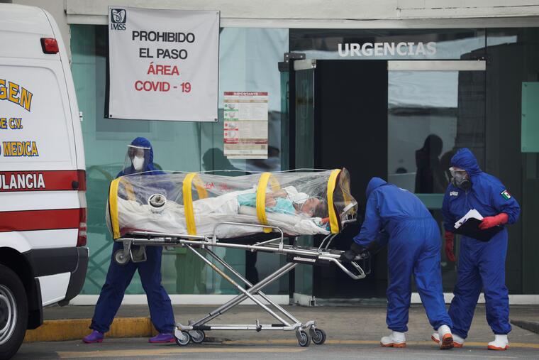 Un paciente que fue dado de alta hospitalaria es subido por paramédicos a una ambulancia para seguir recuperándose en casa, el 7 de mayo de 2020 en Ciudad de México.