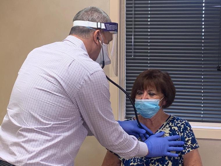 Personal médico en Austin examina a la voluntaria Tina Neira para una vacuna experimental contra el COVID