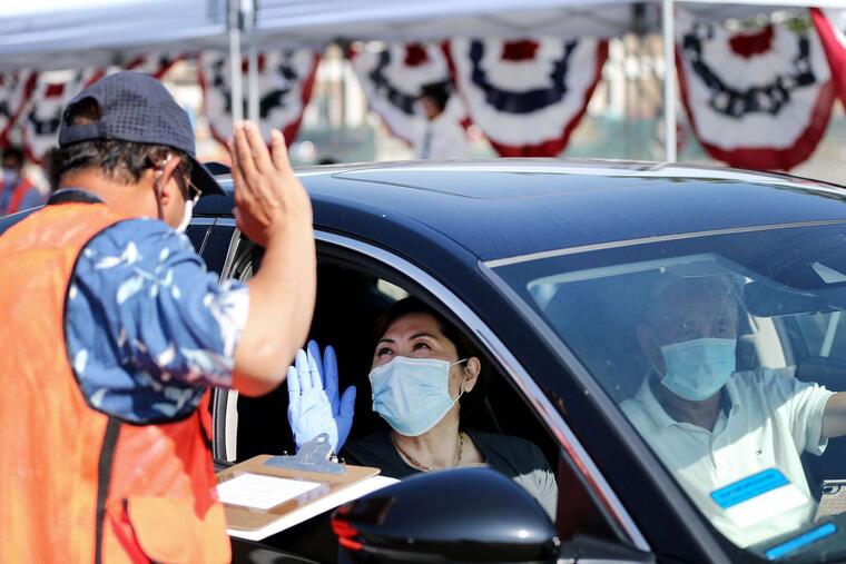 El COVID-19 obligó a realizar las ceremonias de naturalización desde el carro. En la imagen, una mujer se juramentó en Santa Ana, California, el 29 de julio.