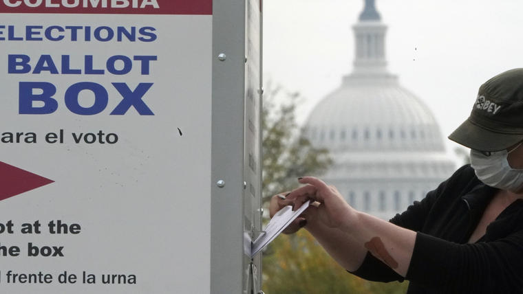 Una votante deposita su boleta en un buzón oficial cerca del Capitolio, sede del Congreso, en Washington D.C. el 28 de octubre de 2020.