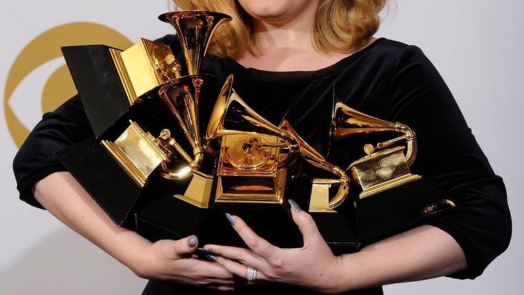 Adele cargando sus premios Grammy en 2012