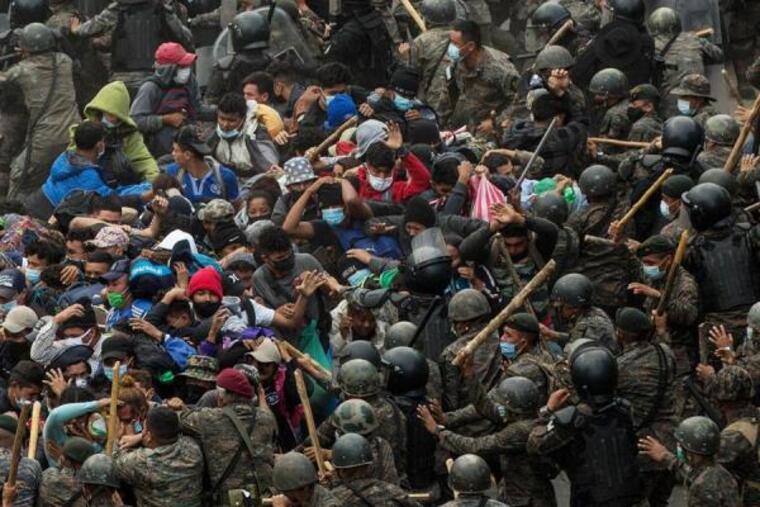 Soldados y policías guatemaltecos golpean a un grupo de migrantes hondureños que caminan por una carretera en Chiquimula este domingo.