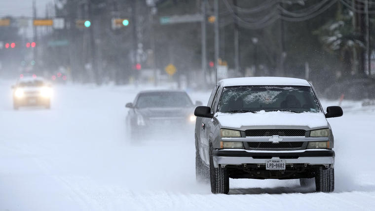 Los vehículos circulan por carreteras cubiertas de nieve y aguanieve el lunes 15 de febrero de 2021 en Spring, Texas