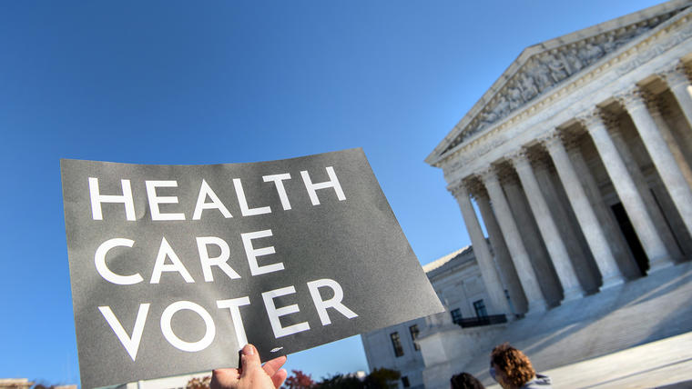 Un manifestante sostiene un cartel frente a la Corte Suprema en Washington, DC, el 10 de noviembre de 2020, cuando el Tribunal Superior abrió argumentos en el caso de larga data sobre la constitucionalidad de la Ley del Cuidado de Salud a Bajo Precio de 2