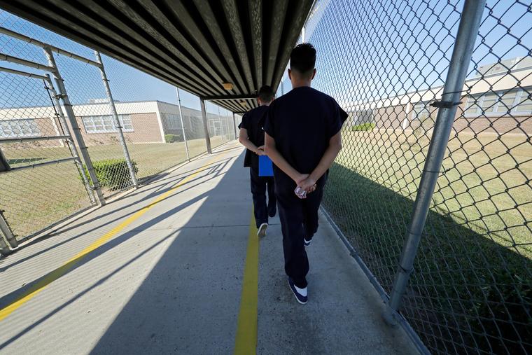 Los detenidos caminan con las manos cruzadas detrás de la espalda dentro del Centro Correccional de Winn en Winnfield, Louisiana, el 26 de septiembre de 2019.