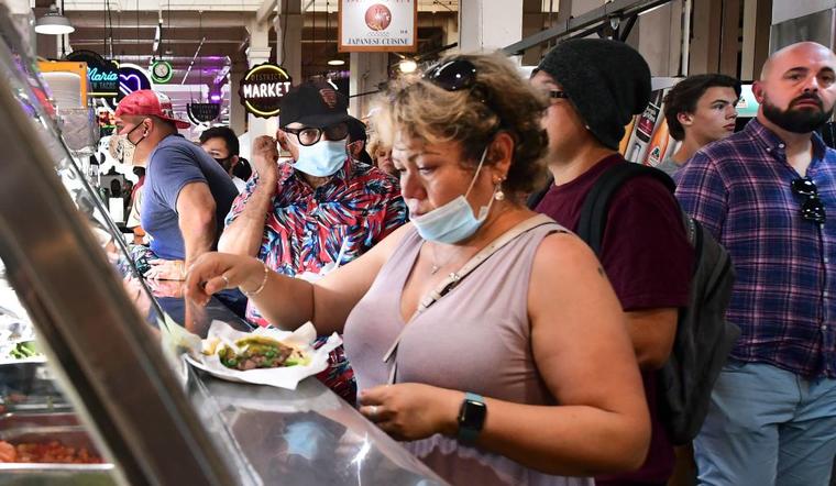 Gente con y sin mascarillas en el Grand Central Market de Los Ángeles, California, mientras la OMS urge a los vacunados volver a usar el tapabocas debido a la rápida propagación de la variante delta.