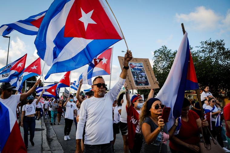 La gente sostiene banderas cubanas en apoyo de los cubanos que se manifiestan contra su Gobierno, en Hialeah, Florida, el jueves.