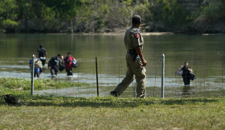 Un oficial de Seguridad Pública de Texas observa mientras un grupo de inmigrantes indocumentados cruza el Río Grande en Del Rio, Texas, el miércoles 16 de junio.