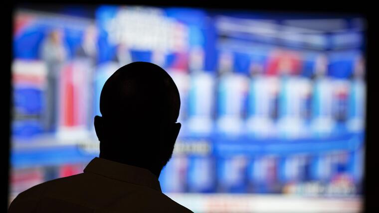 Un hombre observa la transmisión del debate presidencial demócrata realizado el 27 de junio de 2019