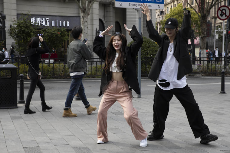 Dos jóvenes bailan en las calles de Wuhan, celebrando el levantamiento de las restricciones. 