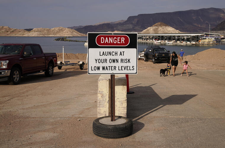 Un letrero advierte de los bajos niveles de agua en una rampa para botes en el lago Mead
