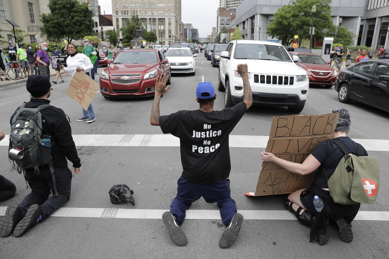 Manifestantes en Loiusville, Kentucky se arrodillan en medio de la calle para bloquear el tráfico, en gesto de protesta por el uso excesivo de la fuerza policial en el caso George Floyd y Breonna Taylor