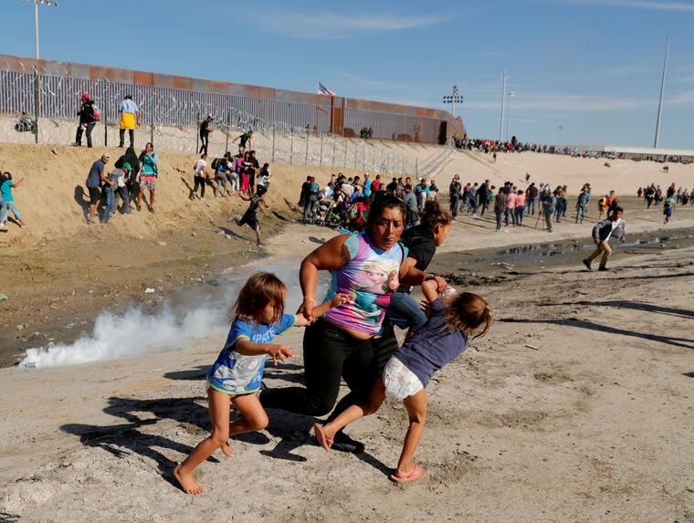Una imagen icónica del 2018. María Meza, de Honduras, huye con sus dos hijas de 5 años de los gases lacrimógenos que lanzó la Patrulla Fronteriza a un grupo de inmigrantes en Tijuana, en la frontera con México, el 25 de noviembre de 2018.