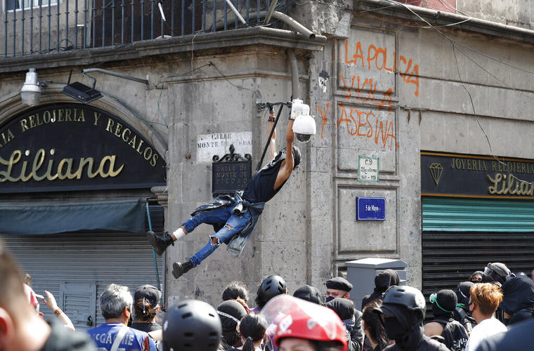 Un manifestante intenta derribar una cámara de vigilancia policial en el centro de Ciudad de México durante una protesta el 8 de junio de 2020.