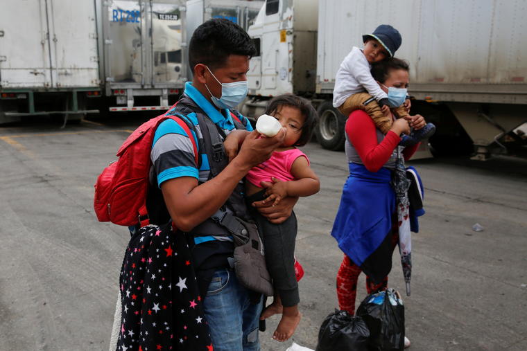 Un hondureño que intentaba llegar a Estados Unidos alimenta a su niña.