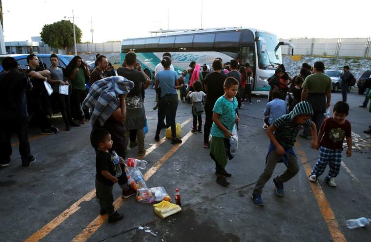 Foto del 16 de julio de 2019, migrantes en el exterior de un centro para migrantes en el Puente Internacional 1, antes de ser trasladados en bus desde Nuevo Laredo a Monterrey, en México. 
