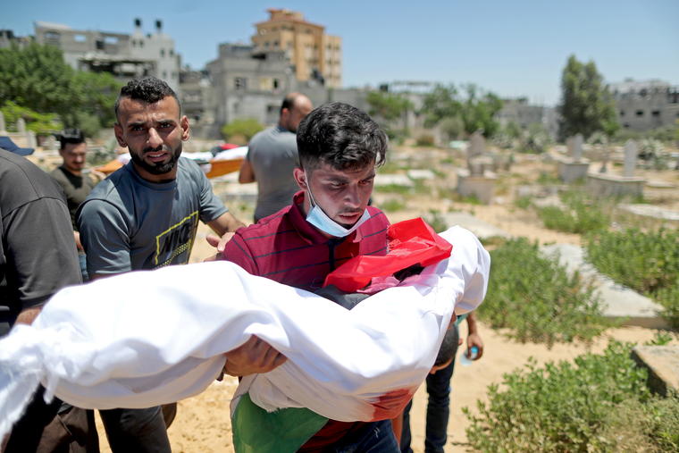 Un hombre lleva el cuerpo de un niño palestino.