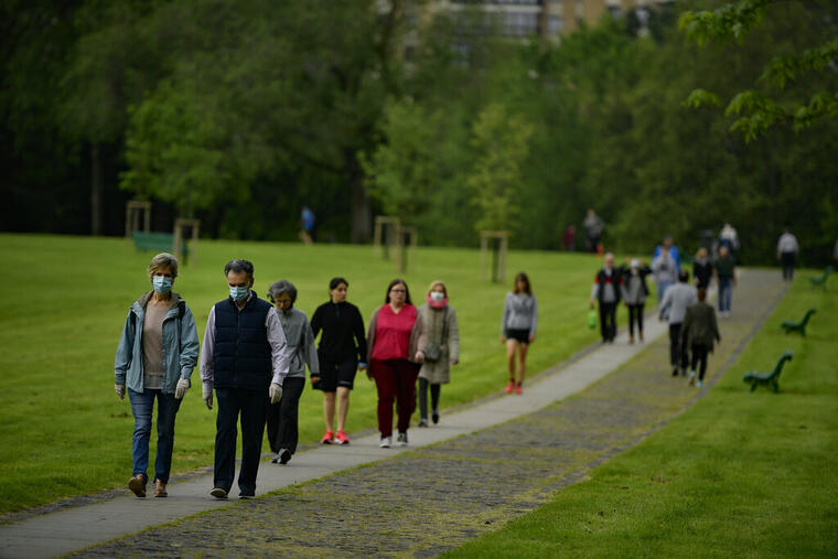 Personas llevan mascarillas de protección mientras caminan en un parque en Pamplona, en el norte de España.