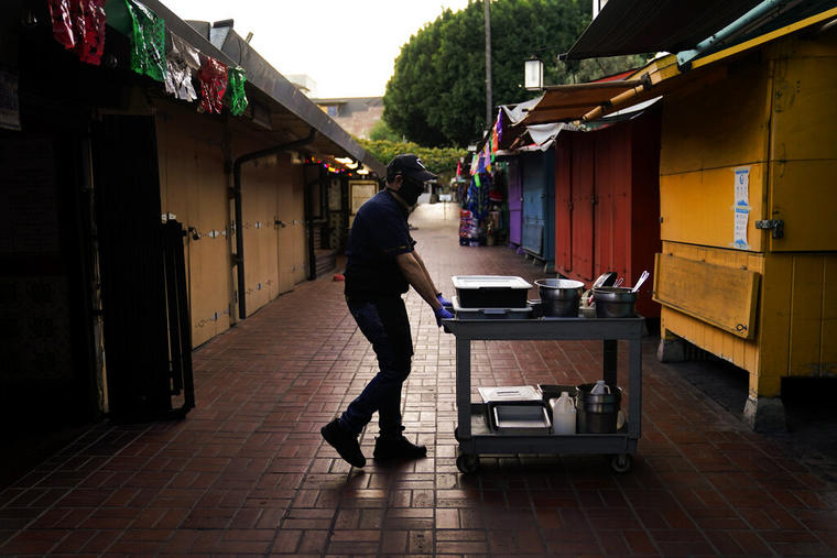 Edward Flores, dueño del restaurante Juanita's Cafe, se mueve entre los negocios cerrados de la calle Olvera de Los Ángeles en diciembre de 2020.