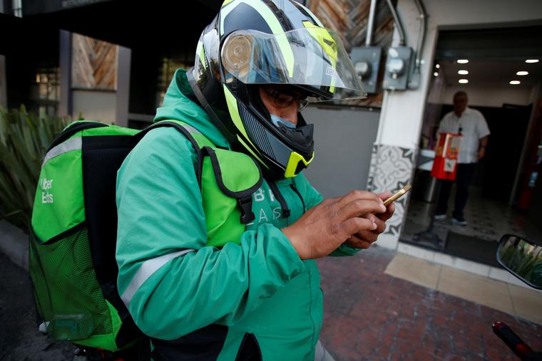 Un repartidor de app, con cubreboca debajo del casco, recoge un pedido en Ciudad de México el 26 de marzo de 2020.